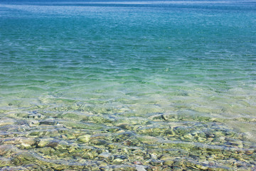 Pebble stones under clear water in the sea