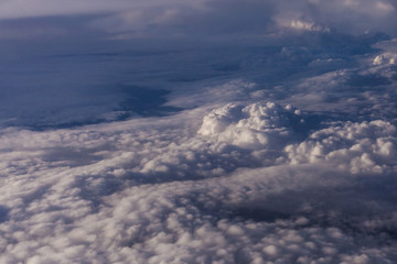 Naklejka premium White clouds and blue sky from an airplane