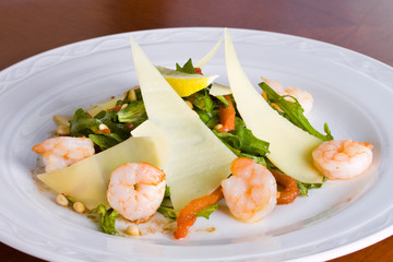Salad with parmesan, shrimps and lemon wedges