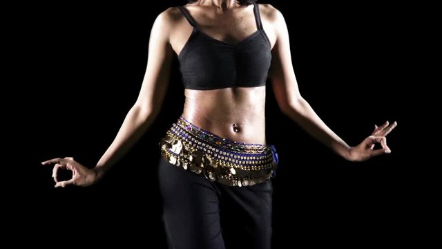 Slow motion of unrecognizable woman belly exercising zumba dance in the studio with dark background