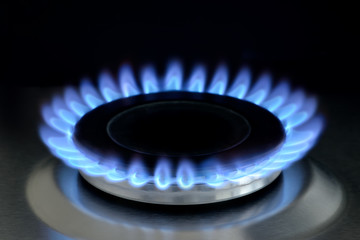 Natural gas burning on kitchen gas stove on black