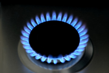 Natural gas burning on kitchen gas stove on black