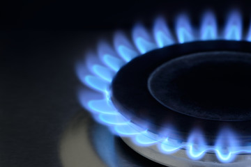 Natural gas burning on kitchen gas stove on black