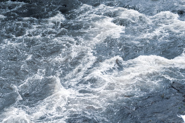 Naklejka premium Background, top view, rapid flow of the river with dark blue water and white foam waves