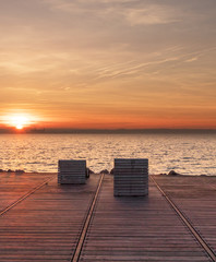 Sun beds at sunset with a view over the ocean Oresund between Denmark and Sweden. Castle Kronborg visible in the distance. View from the Swedish side in the city of Helsingborg. 