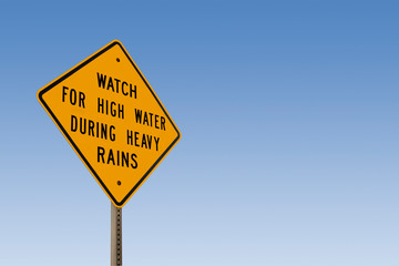 Watch For High Water Sign With Clear Blue Sky