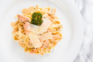 Delicious salmon pasta dish, tagliatelle noodles with Parmesan and parsley.