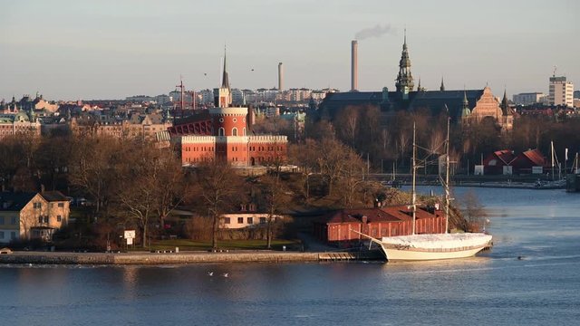 View over boats and islands in Stockholm a spring day in solstice, swans flying by