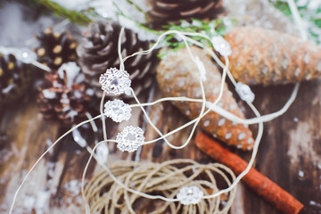 Christmas decor. Fir cones and  juniper branches on a wooden background. Snow still life. Winter.