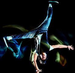 one chinese young man hip hop break dancer dancing isolated on black background with speed light...