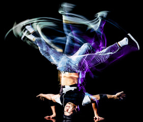 one chinese young man hip hop break dancer dancing isolated on black background with speed light painting effect motion blur