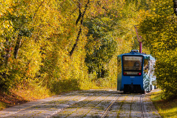 Tram rides through the autumn park