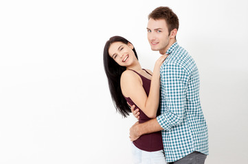 Happy couple embracing and looking camera on white background