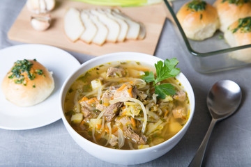 Shchi (cabbage soup) with buns (pampushki), fat and garlic. Traditional Russian and Ukrainian soup. Selective focus, close-up.