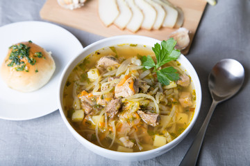 Shchi (cabbage soup) with buns (pampushki), fat and garlic. Traditional Russian and Ukrainian soup. Selective focus, close-up.
