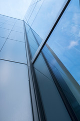 Fototapeta na wymiar detail of modern office building with glass and steel reflecting blue sky