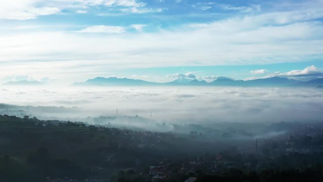 Beautiful aerial view of misty morning in Bandung city with fog covered the city, West Java, Indonesia. Shot in 4k resolution