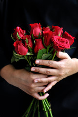 Woman hand holding a bouquet og fresh red roses