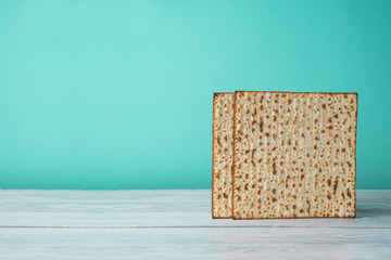 Jewish holiday Passover celebration concept with matzo on wooden table over blue background
