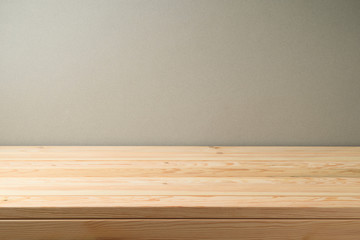 Empty wooden table over grey wall background.