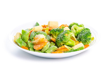 Frozen vegetables on plate on white background isolation