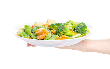 Frozen vegetables on plate hand holding on white background isolation