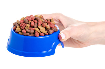 Dry food in a bowl for dogs and cats in hands on a white background isolation