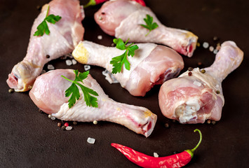 Chicken legs with spices, ready for cooking, background concrete