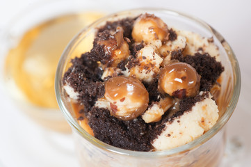 Delicious dessert with hazelnut , chocolate biscuit caramel with tea around white