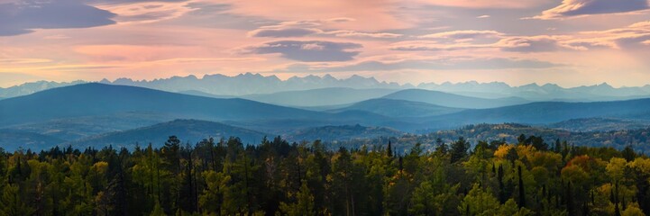 Fototapeta na wymiar Wide angle panorama autumn forest,misty hills mountain tops in pink dawn
