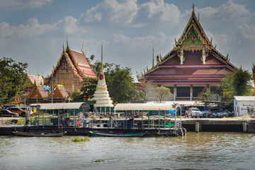 Fototapeta na wymiar Casas y templos budistas en la orilla del rio Chao Phraya, navegando hacia Bangkok, Tailandia