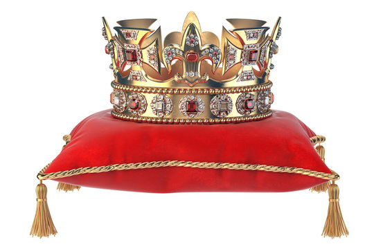 Golden crown with jewels on red velvet pillow for coronation isolated on white.