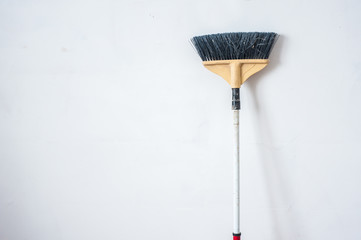 Close up of red black broom on white background