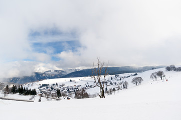 Fototapeta na wymiar Hofsgrund im Schwarzwald im Winter mit Wolkenhimmel