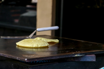 Mexican fresh corn tortillas being cooked on a traditional 