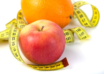 Apples and orange with measure tape on white background, healthy diet
