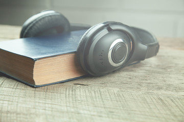 Obraz na płótnie Canvas earphone and book on the wooden table