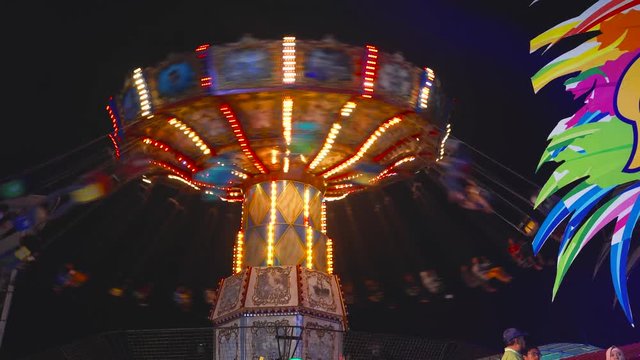 Malang, East Java, Indonesia - February 13, 2019: Wave swinger ride at night in Batu Night Spectacular Amusement Park. Shot in 4k resolution