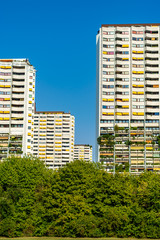 Fototapeta premium White residential buildings with green plants on the balconies and yellow awnings