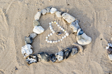 heart made of stones and shells on the beach