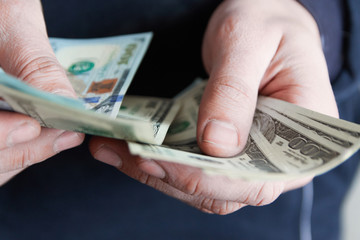 Man holdin money. Concept of savings, salary, payment and funds. Man counts cash bills..