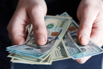 Man holdin money. Concept of savings, salary, payment and funds. Man counts cash bills..