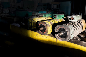 Spare old electric motors in a warehouse of industrial materials.
