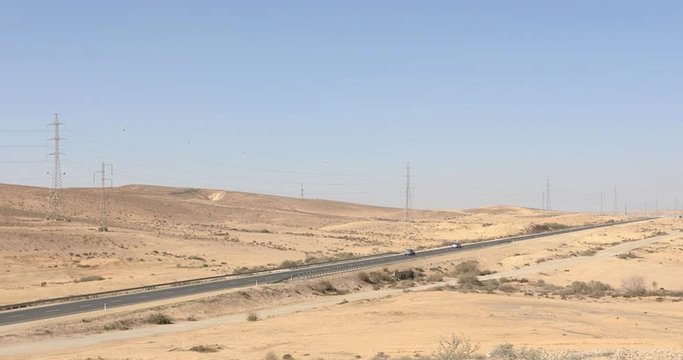 Two pairs of moving cars on long road in desert at winter