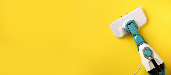 Steam cleaner mop on yellow background. Top view, flat lay. Banner with copy space. Cleaning service concept