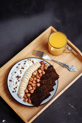Delicious healthy Breakfast in the morning. Rye bread, banana, hazelnut, chocolate muesli, yogurt and fresh orange juice