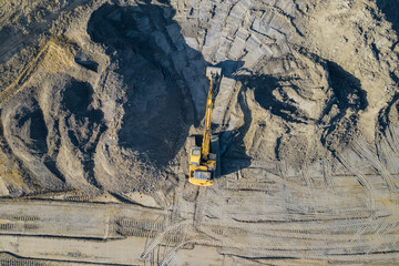 Aerial view of excavator and construction equipment. Machinery and mine equipment from above. Top view of industrial place. Photo captured with drone.