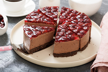Cold chocolate cheesecake with cherry jelly.