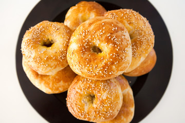 Fresh baked bagle buns with sesame seeds on white background