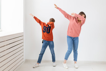 Fun, mothers day, children and family concept - teen boy and his mom funny dancing on white background